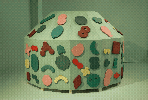 A gif of a participatory sculpture by Pinaffo & Pluvinage in which colorful shapes move on a geometric surface, spun around from inside or outside.