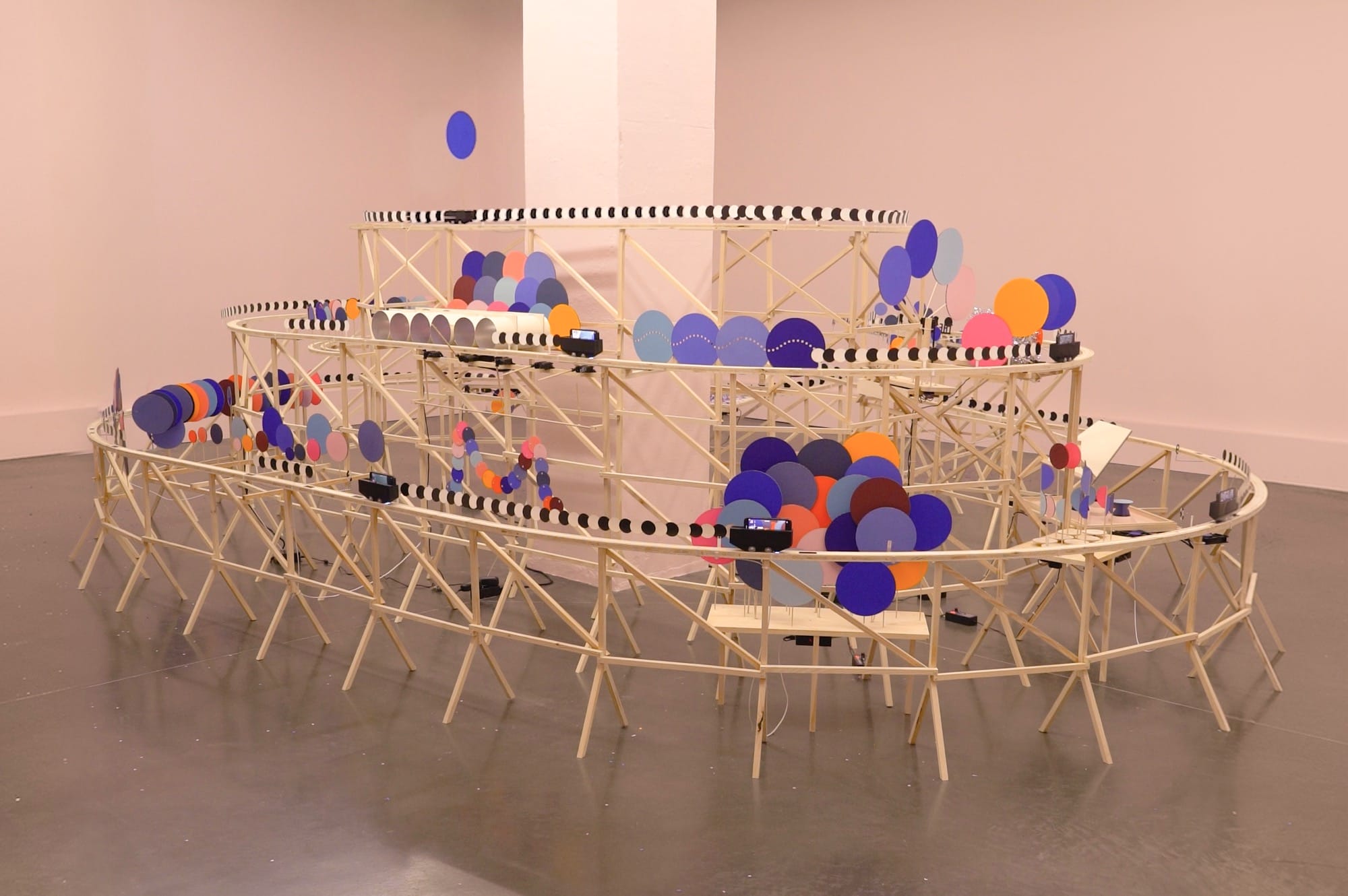 An installation by Pinaffo & Pluvinage of colorful discs on a track framework.